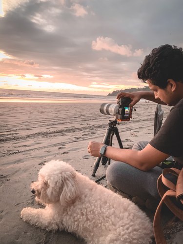 Azar photographing a beach sunset with his dog, Quepos, Puntarenas