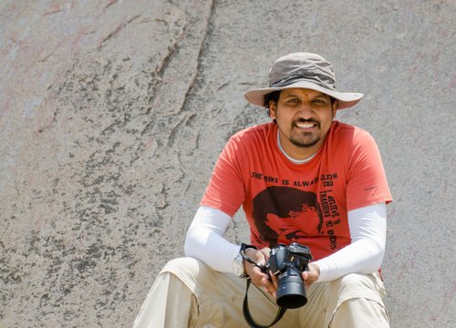 Azar seated with his camera and sun hat, Shravanabelagola, Karnataka
