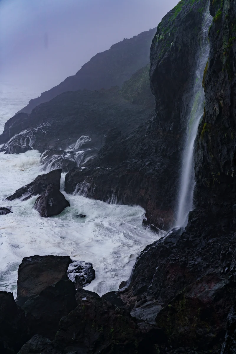 Waterfall meeting the rocky Oregon coast, Florence
