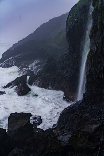 Waterfall meeting the rocky Oregon coast, Florence